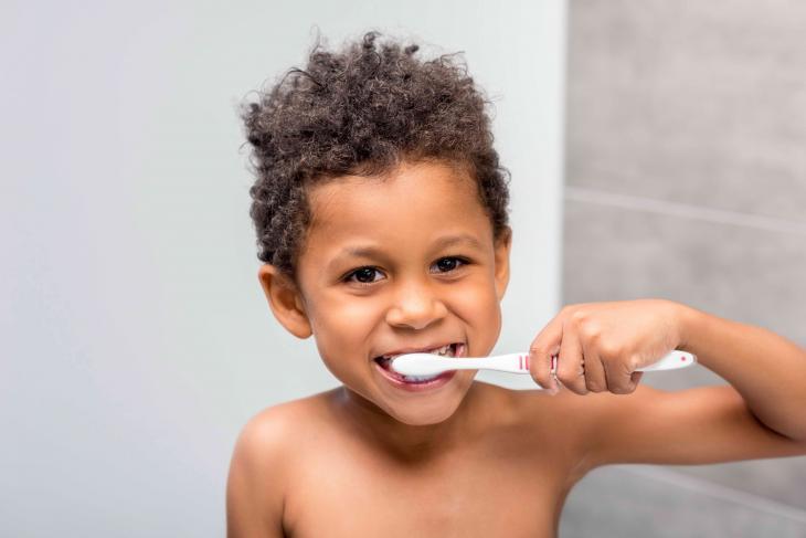 Imagem de uma menino escovando os dentes