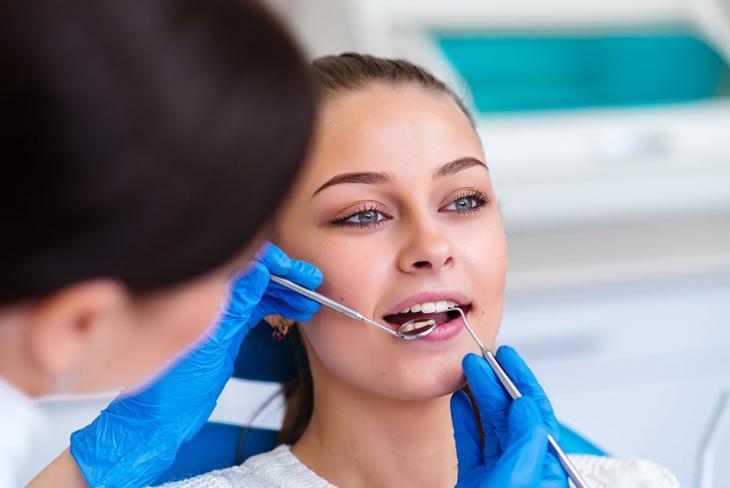 Imagem de uma mulher durante uma consulta com uma dentista
