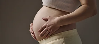 Gestante, passando as mãos na barriga