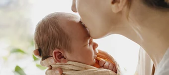 Mãe beijando o seu filho bebe.