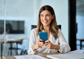 Mulher sorrindo enquanto utiliza o celular, representando facilidade e segurança no acesso aos boletos da Hapvida.